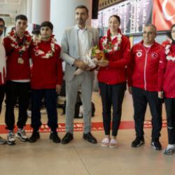 &Ccedil;i&ccedil;eklerle karşılandılar! Milli sporcular yurda d&ouml;nd&uuml;