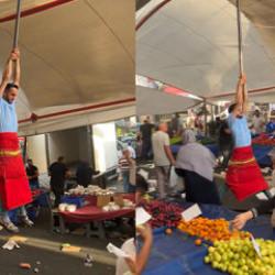 Kuvvetli r&uuml;zgarda pazarcı branda direğini bırakmadı, metrelerce havaya y&uuml;kseldi