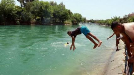 Adana’da sıcaktan termometreler patladı, çocuklar su kanalında serinledi