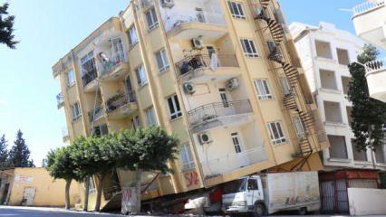 İskenderun'da yan yatan ağır hasarlı binayı altında kalan kamyonet ayakta tutuyor