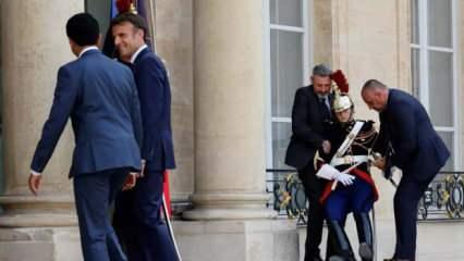 Yanındaki muhafız sıcaktan bayıldı Macron poz vermeye devam etti