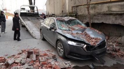 Yıkım aşamasındaki binanın bağlantı noktaları kesilen duvarı ara&ccedil;ların &uuml;zerine devrildi