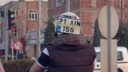 Diyarbakır&rsquo;da ilgin&ccedil; g&ouml;r&uuml;nt&uuml;: D&uuml;şen plakasını kaskına bantlayıp trafikte ilerledi