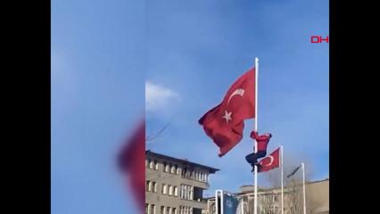 R&uuml;zgarda dolanan bayrağı d&uuml;zeltmek i&ccedil;in direğe tırmanan &ccedil;alışan g&ouml;n&uuml;llerl fethetti