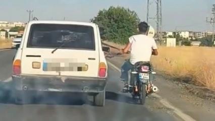 Şanlıurfa'da tehlikeli yolculuk: Motosiklet, otomobil kemerine tutunarak ilerledi