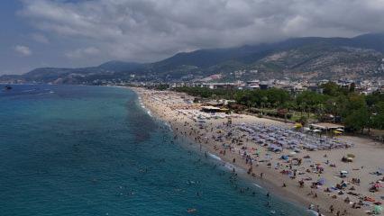 Alanya&rsquo;da hava sıcaklığı arttı, turistler soluğu &uuml;nl&uuml; plajlarda aldı