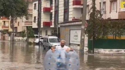 Tarsus sokaklarında ilgin&ccedil; g&ouml;r&uuml;nt&uuml;: Yağmurda ıslanmaya "balonlu" &ccedil;&ouml;z&uuml;m!