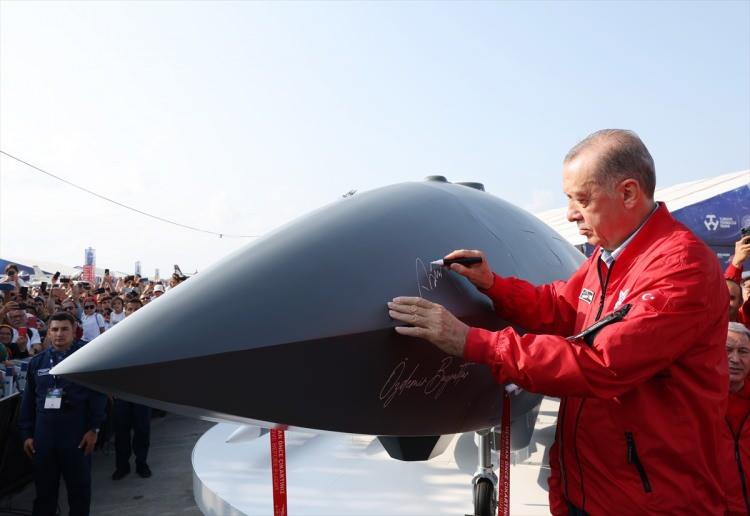 <p>Cumhurbaşkanı Erdoğan, burada Bayraktar Kızılelma ve Hürkuş uçaklarını imzaladı, uçakların önünde poz verdi.</p>
