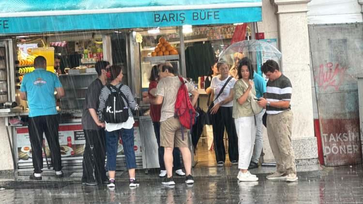 <p>Bazı vatandaşlar sağanaktan şemsiyeyle korunmaya çalışırken, bazıları da tramvay durakları ve binaların altlarındaki <a href=