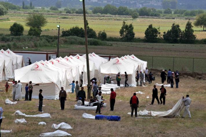 Suriyeli mülteci kadınlar, Güveçci köyüne yakın, Suriye'nin kuzeyindeki İdlib'de geçici bir kampta bekliyor.