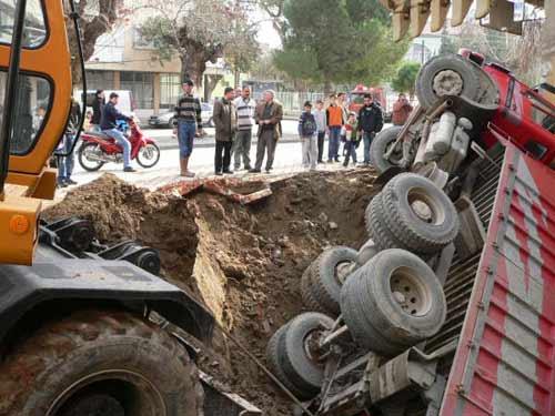 Manisanın Turgutlu ilçesinde bir inşaat firmasına ait kamyon bina temeli için kazılan çukura düştü