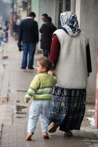 Hava yağmurlu ve soğuk, yerler ıslak ama ismi bile öğrenilemeyen minik kız bir terliğini kaybettiğinin farkında bile değil. Bir kaç metre ötede ise yasadışı gösteri yapanlar ile polisler kapışmış durumda.