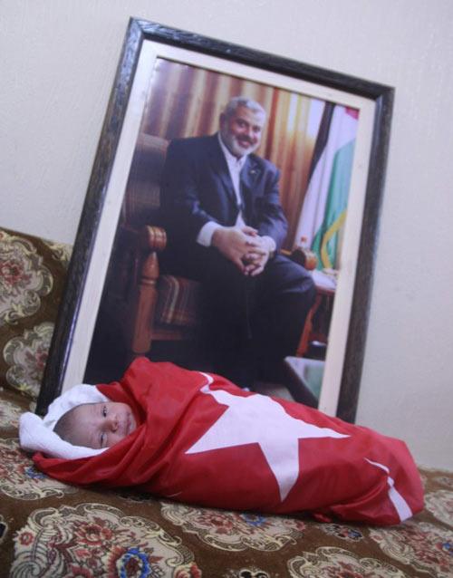 ERDOGAN BEBEK DEDESI HANIYE'NIN RESMININ ONUNDE.