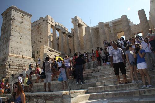 Akropoldeki Tanrıça Athenaya adanan Parthenon Tapağınağına çıkan merdivenlerden turist kalabalığından adım adım ilerleniyor.