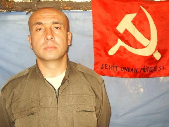 Terörist Orhan Yılmazkaya üst düzey yöneticisi olduğu Devrimci Karagah Örgütü'nün sözde bayrağı önünde
