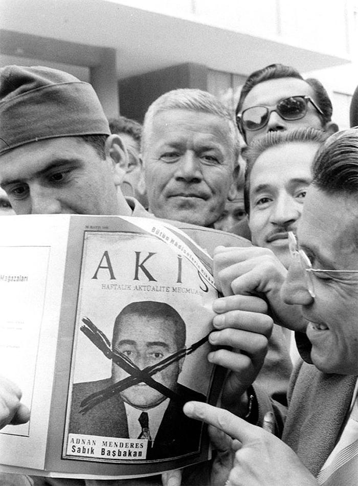 ÇARPI ATILMIŞ MENDERES
İsmet İnönünün damadı Metin Tokerin çıkardığı Akis dergisi, dönemin en etkili yayın organlarından biriydi. Muhalif yayınlarıyla Demokratların tepkisini çeken Akis, askerler için bir başucu kitabı gibiydi. 27 Mayıstan 3 gün sonra 30 Mayıs günü, kapağında Başbakan Menderesin fotoğrafıyla çıktı. Ama fotoğrafın üzerine bir çarpı atılmış, altına da Sabık Başbakan diye yazılmıştı. Fotoğrafta Akisin bu tarihi sayısı, yollarda kutlama yapan vatandaşlarla askerlerin elinde görünüyor.