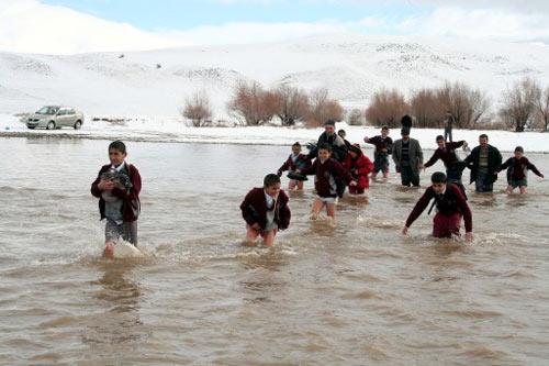 AGRI'NIN TUTAK ILCESI ADAKENT KOYUNDE ERKEK OGRENCILER, KOPRU BULUNMAMASI NEDENIYLE ELMALI NEHRI'NI YURUYEREK ASIP ILCEDEKI OKULA ULASIYOR. (ANADOLU AJANSI - SEREF YILDIRIM)
