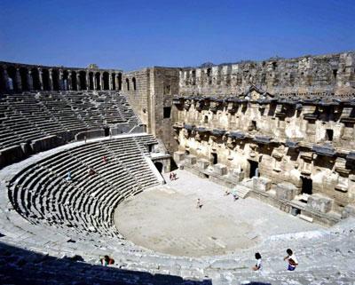 ASPENDOS
Opera izlemenin zevki

Anadoludaki Roma tiyatrolarının bugüne sahnesiyle ulaşabilen en eski ve sağlam örneği. 15 bin kişinin konser seyredebildiği tiyatronun çok iyi bir akustik yapısı var. En arka yani 41inci sırada oturan biri sahnede mikrofonsuz hatta alçak sesle konuşan kişiyi bile rahatlıkla duyabilir. Genelde açıkhava konserlerini sevmeyen Doğan Hızlan yine de Aspendosu niye sevdiğini açıklıyor: Tarihi mekanlarda konserlerin opera sahnelemelerinin ayrı bir görkemi olduğununu inkar edemem. Aspendosta bu ay boyunca Anadolu Ateşinin Troya gösterisi var.