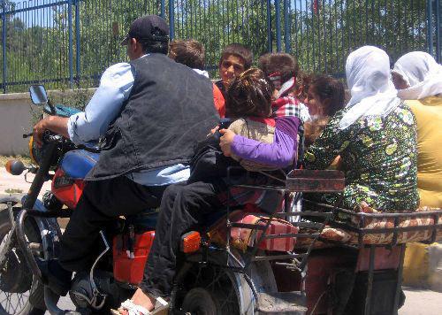 2 kadın, 7 çocuk ve sürücünün bindiği motosiklet tehlikeye aldırış etmeden yoluna devam etti. Şoförün arkasına oturan bir çocuğun küçük bir bebeği kucağında taşıması ise tehlikenin boyutunu gözler önüne serdi.