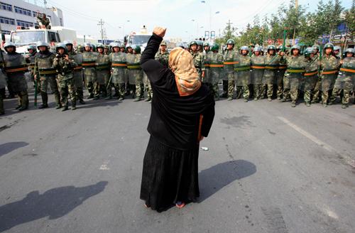 Uygur Türklerini temsilen Çin güvenlik güçlerine hitaben protestolarına devam eden bir kadını izliyoruz. 7 Temmuz 2009 tarihine damgasını vuran bu kadın, Müslümanların mücadelesini temsil eden bir fotoğraf niteliği taşıyor. (REUTERS/David Gray)