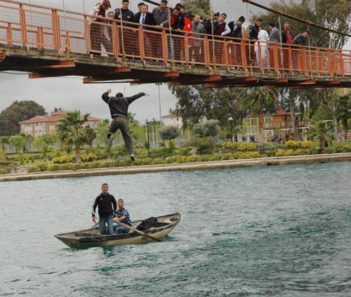 ADANA'DA AİLESİNİN, SEVDİĞİ KIZLA EVLENMESİNE İZİN VERMEDİĞİ GENÇ, OKUL MÜDÜRÜNE MEKTUP BIRAKARAK, SEYHAN NEHRİ ÜZERİNDE BULUNAN SİNANPAŞA KÖPRÜSÜ'NDEN ATLAYARAK İNTİHAR GİRİŞİMİNDE BULUNDU. GENCİN NEHRE ATLAMASI SANİYE SANİYE KAMERALARA YANSIDI.FOTOĞRAF: FATİH KEÇE