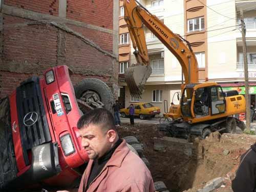 Manisanın Turgutlu ilçesinde bir inşaat firmasına ait kamyon bina temeli için kazılan çukura düştü