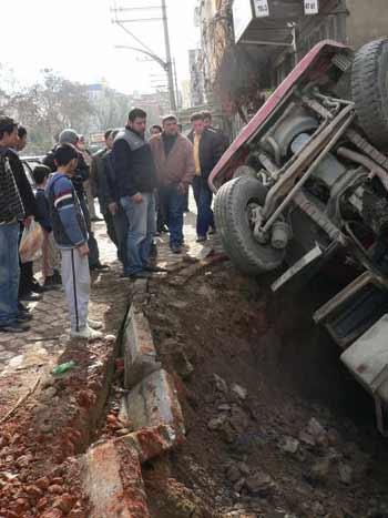 Manisanın Turgutlu ilçesinde bir inşaat firmasına ait kamyon bina temeli için kazılan çukura düştü