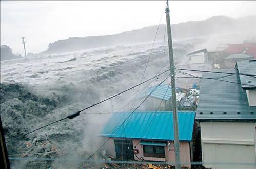 Yeterince yüksek değil: Miyako kentinde dalgakıranları da aşan tsunami dalgaları.