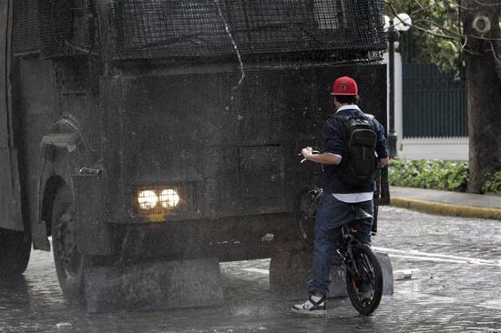 Şili'nin Santiago kentinde okulları kapatılan öğrenciler sokağa çıktı. Gösteriye katılan liseli öğrenci kalabalığa müdahale eden çevik kuvvet aracına bisikletiyle kafa tuttu.