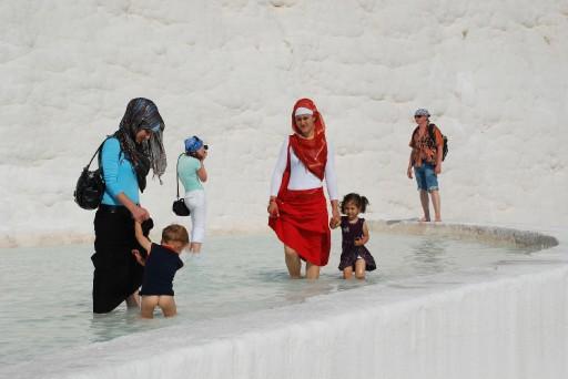 PAMUKKALE'DE, YABANCI TURISTLER KENDINI DENIZDE HISSEDER GIBI MAYOLARIYLA SULARIN ICINE GIRIP UZANMAYI, TURK TURISTLER ISE DAHA COK BEYAZ TRAVERTENLER UZERINDE GEZINTI YAPMAYI TERCIH EDIYOR