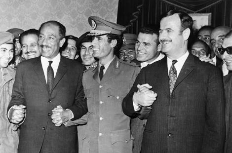 Araplar bir arada!!
İktidarının ilk yıllarında, Kaddafi, kendi tanımıyla Arap halklarını bölmek için sömürge güçlerinin belirlediği sınırları ortadan kaldırmak için çalıştı. Arap Cumhuriyetleri Federasyonunun organizasyonunda önemli rol oynayan Kaddafi, Libya, Mısır ve Suriyeyi aynı çatı altında topladı. Fotoğrafta, üç ülkenin liderleri görülüyor. Mısır Devlet Başkanı Enver Sedat, Kaddafi ve Suriye Devlet Başkanı Hafız Esad, ittifaklarını belirleyen anlaşmaya imza atıyor. Ancak federasyon üç ülkeye de pek fayda getirmezken, zamanla üye ülkeler arasındaki ilişkiler bozuldu.