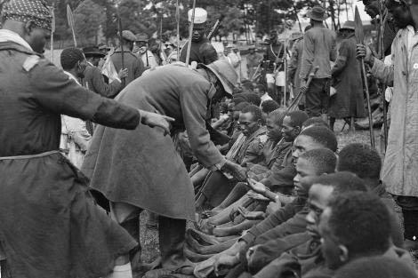 Kikuyu muhafızları, isyancıların ellerindeki işaretleri inceliyor.