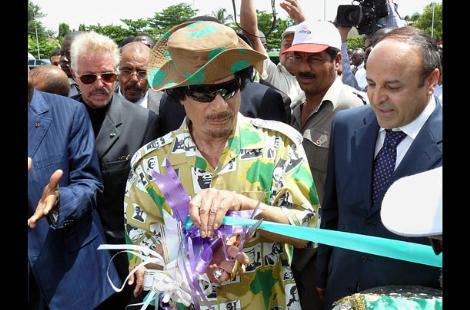 Gösteriş Düşkünü!
Kaddafi giyim kuşam ve aksesuar konularında benzersiz bir zevki olduğuna inanıyor. Örneğin 2008de Libyanın Cotonou şehrindeki bir iskelenin kurdele kesme töreninde girdiği bu kamuflaj esintili gömlek şapka ve güneş gözlükleriyle tamamlanmış.