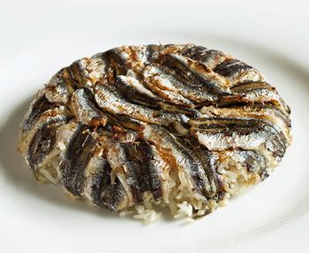 Hamsili Pilav tarifi:
Malzemeler
1 kg hamsi
2 su bardağı pirinç
2 soğan
1 kahve fincanı zeytin yağı
1 demet yeşil soğan
Yarım demet taze nane
1 tatlı kaşığı toz şeker
Kuşüzümü
Dolmalık fıstık
Tuz
kara biber
Yapılışı
Hamsileri temizleyip mısır unuyla harmanlayın. 10-15 dk bu halde bekletin. Pirinci parlak ve güzel olması için bir tatlı kaşığı tuz ve limonlu suda bekletin.
Soğanları kıyın, zeytinyağını ısıtıp tencerenin içine atın. Kavurduktan sonra fıstıkları ve ardından pirinç ve suyu ekleyin.
Kaynattıktan sonra pirinçlerin suyunu çekmesi için bekletin. Ocaktan alıp içine tuz, şeker, kıyılmış yeşil soğan ve baharatları ekleyin.Tencerenin kapağı kapalı bir biçimde dinlenmeye bırakın.(15 dakika kadar)
Isıya dayanıklı derin kaselerin veya tek bir borcamın içini yağlayın. Dibini hamsi filetolarıyla kaplayın. Üzerine pilav yayın. Ardından üzerine de hamsileri koyun. 170 dereceye ayarlanmış fırında kızarana kadar pişirin. Fırından aldıktan sonra ters çevirerek servis yapın.