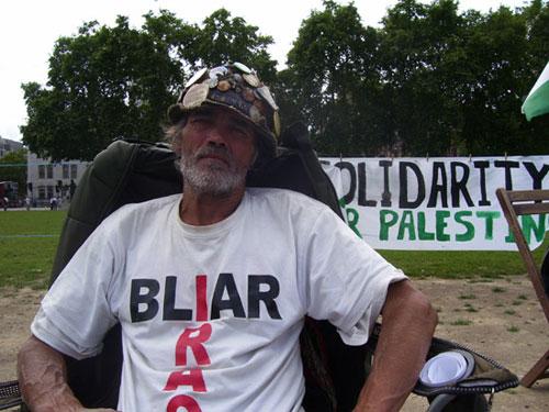 İngiliz Hükümeti'nin baş edemediği protestocu Brian Haw çadırın yanına diktiği Filistin ve Irak bayraklarıyla kendi deyimiyle diktatörlüğe karşı mücadele ediyor.