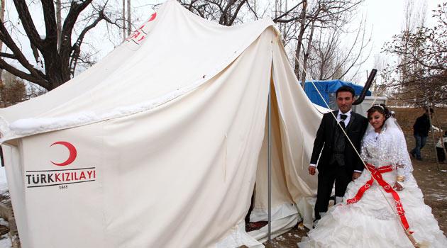 D&uuml;ğ&uuml;nlerini b&ouml;yle hayal etmemişlerdi. Van'ın Erciş il&ccedil;esinde 29 Ekimde yapılacak d&uuml;ğ&uuml;nlerini deprem nedeniyle erteleyen Sefa ve Zehra Yıldız &ccedil;ifti, &ccedil;adırda d&uuml;nya evine girdi.