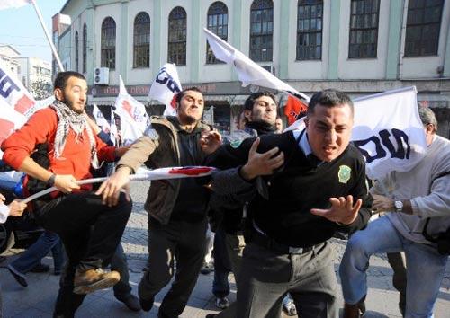 MEMURLARIN BIR GUNLUK 'UYARI GREVI' EYLEMINE KATILAN COK SAYIDA GRUP YURUDU. YURUYUS SIRASINDA BIR BANKANIN DUVARINA YAZI YAZMAK ISTEYEN BIR GRUP ILE GUVENLIK GOREVLISI ARASINDA ARBEDE YASANDI.