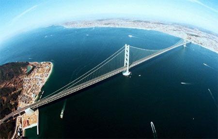 <p><strong><span style="text-decoration: underline;">Japonya'daki Akashi-Kaikyo Köprüsü, 1991 metre uzunluğuyla dünyadaki en uzun asma köprüdür.<br /></span></strong><br />İki tane 282 metrelik kulesi bulunan köprü, Richter ölçeğine göre 8.5 büyüklüğünde oluşabilecek depreme dayanıklı olarak inşa edilmiştir. Ayrıca saatte 290 kilometre hızla esen tayfunlara da dayanıklıdır.</p>
<p>Bu köprünün bu kadar uzun olmasının sırrı merkezi asma açıklığı ile kablo destekli köprü yapılarının uzatılmasına bağlıdır. Yenilikçi yapı tasarımları bugüne kadar bizi esir almıştı. Ancak burada anahtar yeni materyallerde gizlidir. Diğer yapı alanlarının birçoğunda olduğu gibi karbon nanotüpler gelecek vaat ediyor. Halat gibi birbirine sarmalanan uzun teller eşsiz gerilme direnci ile hafifliği birleştiriyor.</p>