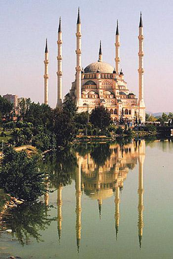 <b><U>Sabancı Merkez Camii - Adana</U></b><br><br>

<b>Minareler imanın altı şartını ifade ediyor</b><br><br>

Adana'nın Reşatbey semtinde, Seyhan Nehri'nin batı kıyısında yeşillikler içinde yükseliyor Sabancı Merkez Camii. Adımınızı atar atmaz Süleymaniye Camii'ne gelmiş hissine kapılıyorsunuz. Dış mimaride Süleymaniye'den esinlenilmiş. Plan ve iç mekan olarak da Selimiye Camii'ne benziyor. Daha baştan gözünüzden kaçmayan ziyaretçi yoğunluğu ve 6 minaresiyle de Sultanahmet'i getiriyor akıllara. 1998'de ibadete açılan Sabancı Merkez Camii'nin 6 minaresi imanın altı şartına işaret ediyor. Sadece minareleri değil, mimarideki neredeyse her bir ayrıntının dini literatürde karşılığı var. Mesela ana mekândaki 5 normal kubbe İslam'ın beş şartını, minberdeki basamakların sayısının 23 olması Kur'an-ı Kerim'in 23 yılda nazil olmasını, caminin 8 ana giriş kapısı 8 cennet kapısını, 32 metrelik ana kubbe çapı 32 farzı ifade ediyor. Sultanahmet'e benzer bir diğer yönü de 6 minarede toplam 16 şerefe bulunması. Bu da tarih boyunca kurulmuş 16 Türk devletine işaret ediyor. İki mekandaki toplam kubbe sayısının 33 olması, tesbih, tahmîd ve tekbirin ayrı ayrı 33 defa tekrarını temsil ediyor. Şadırvandaki avluda 28 kubbe çarpıyor göze. Bunlar da Kur'an'da adı geçen 28 peygamberi ifade ediyor.<br><br>

<b>Zaman - Cuma</b>